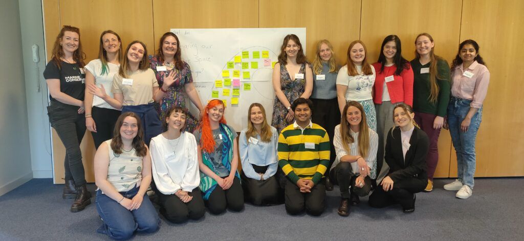 a group posing for a photo in front of a whiteboard