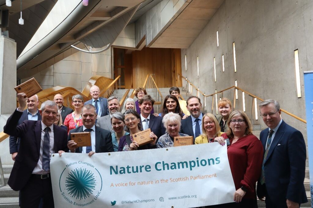 A group of MSPs standing in front of a banner that says nature champions